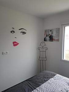 ein Schlafzimmer mit einem Frauengesicht an der Wand in der Unterkunft maison individuelle 500 m de la mer in Agon Coutainville