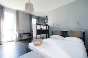- une chambre avec un grand lit blanc et un bureau dans l'établissement Via Mentana 32 - The House Of Travelers, à Côme
