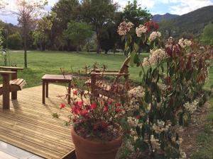 a wooden deck with a bench and flowers at Ernella in Aléria