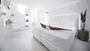 1 dormitorio blanco con 1 cama blanca grande con sábanas blancas en Q Hotel, en Rímini