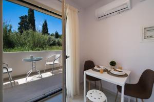 a room with a balcony with a table and chairs at Bounatsa Studios & Apartments in Nydri