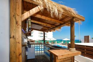 a bar with a straw roof next to a swimming pool at Seafront Protaras Villas in Protaras