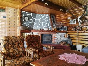 a living room with two chairs and a fireplace at Kukka Holiday House in Kukka