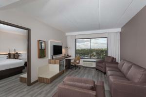 a hotel room with a bed and a living room at Wyndham Garden Ft Lauderdale Airport & Cruise Port in Dania Beach