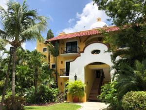 a yellow and white house with palm trees at Occidental Cozumel - All Inclusive in Cozumel
