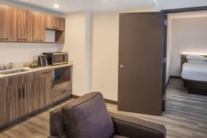 a room with a kitchen and a bed and a microwave at Wyndham Garden Ft Lauderdale Airport & Cruise Port in Dania Beach