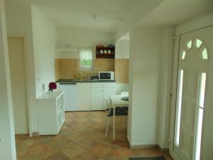 a kitchen with white cabinets and a table in it at COSTABELLA VISTA in Rijeka