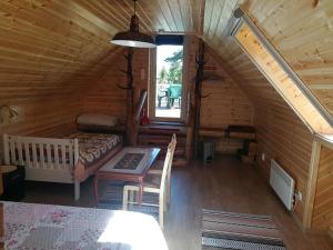 Habitación con cama y mesa en una cabaña de madera en Kukka Holiday House en Kukka