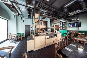 a restaurant with tables and chairs in a room at Maison Schiller by DesignCity Hotels in Munich