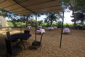 a table and chairs under a tent with a table and chairsktop at Hôtel restaurant LOGIS HOTELLERIE DE BALAJAN in Vic-la-Gardiole