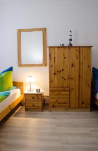 a bedroom with a large wooden cabinet and a bed and a table at Ostsee Ferienpark B-2-1 Ferienwohnung Willebrand in Heiligenhafen