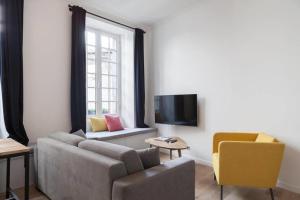sala de estar con sofá y TV en Chemin du muguet, en Burdeos