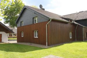 ein großes Holzgebäude mit einem Rasenplatz in der Unterkunft Ferienwohnung Haus Stein in Monschau