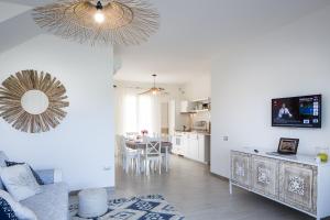 a living room filled with furniture and a tv at Residence Mar Mediterraneo in Quartu SantʼElena