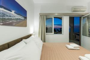 a bedroom with a bed with two towels on it at Kolimbito Sea Side in Falasarna