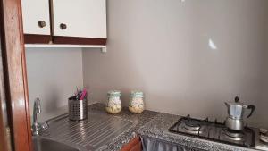 un bancone della cucina con piano cottura e lavandino di Casa Rosmary a Cefalù