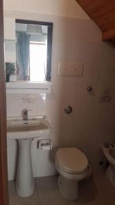 bagno con servizi igienici, lavandino e finestra di Casa Rosmary a Cefalù