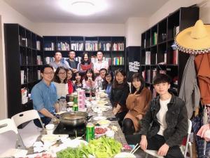 um grupo de pessoas sentadas à volta de uma mesa com comida em Youth Space em Guangzhou