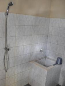 a shower in a tiled bathroom with a tub at Arjuna Homestay Ubud in Ubud +55 photos