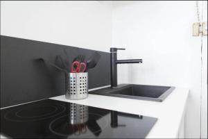 a kitchen counter with a sink and a cup of utensils at Quai bourgeois in Bordeaux