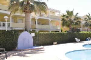 un gran edificio con una palmera y una piscina en Estrella Blanca II, 2 dormitorios, by Bookindenia, en Denia