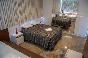 ポソス・デ・カルダスにあるHotel Pousada Beija Florのベッド2台とバスルームが備わるホテルルームです。