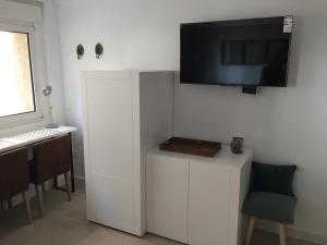 a white room with a desk and a television on the wall at EVE Malagueta in Málaga