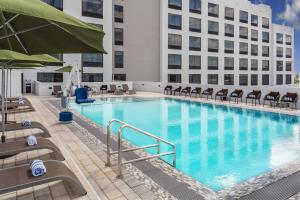 a large swimming pool with chairs and a building at Wyndham Garden Ft Lauderdale Airport & Cruise Port in Dania Beach