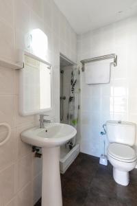 a white bathroom with a sink and a toilet at PARADISE IBIZA ( Apto. Turístico 1 llave ) in San Antonio