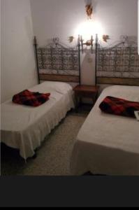a bedroom with two beds and a light on the wall at PARADIS TOSSA in Tossa de Mar