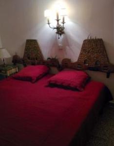 a bedroom with a red bed with two red pillows at PARADIS TOSSA in Tossa de Mar