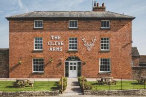 a brick building with a sign that reads the give arms at The Clive Arms in Ludlow