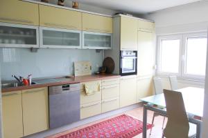 une cuisine avec des armoires jaunes et une table avec une salle à manger dans l'établissement Villa Lina, à Sarajevo