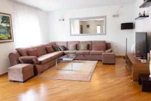 - un salon avec un canapé brun et un miroir dans l'établissement Villa Lina, à Sarajevo