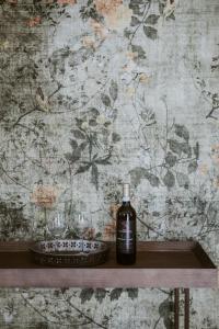 a bottle of alcohol sitting on a shelf next to glasses at Ca Muretta Relais in Bardolino