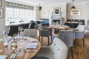 a restaurant with tables and chairs and a fireplace at The Clive Arms in Ludlow