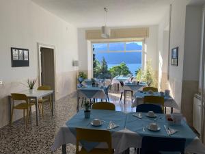 a restaurant with blue tables and chairs and a large window at Hotel Loveno in Menaggio