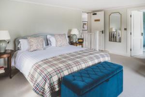 sypialnia z dużym łóżkiem z niebieską otomaną w obiekcie The Clive Arms w mieście Ludlow