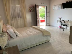 - une chambre avec un lit, une table et un bureau dans l'établissement L'oasi di Ambra, à Ardea