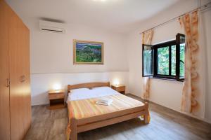1 dormitorio con cama y ventana en Apartment Ema, en Premantura