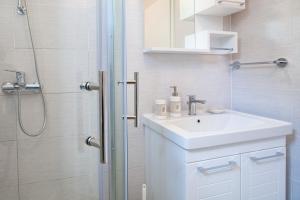 a white bathroom with a sink and a shower at Apartment Ema in Premantura