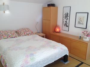 a bedroom with a bed and a dresser at la maison bleue in Carros