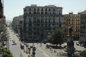 a city street with a statue in front of a building at Hotel Nuovo Rebecchino in Naples
