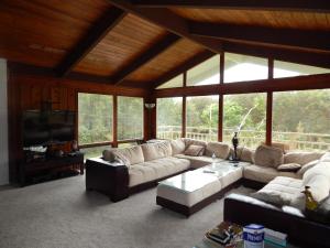 a large living room with couches and a television at Fern Forest Getaway in Volcano