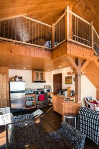 a large kitchen with a wooden ceiling with a loft at Maison sur la plage TERRE-MÈRE in Grenville-sur-la-Rouge