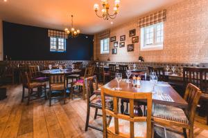 a restaurant with wooden tables and chairs and a chandelier at The Dog & Doublet Inn in Stafford