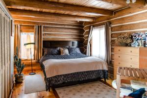 1 dormitorio con 1 cama y pared de madera en Le petit Montebello, en Grenville-sur-la-Rouge