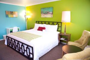 ein Schlafzimmer mit einem großen Bett und einer grünen Wand in der Unterkunft Quail Park Lodge in Kanab
