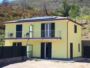 a yellow house with a balcony on top of it at Levanto House in Levanto