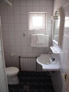 a bathroom with a sink and a toilet and a mirror at Angela Hotel in Berettyóújfalu